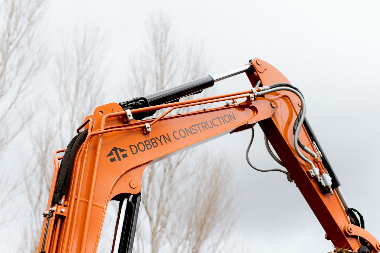 Dobbyn Construction branding on an orange excavator