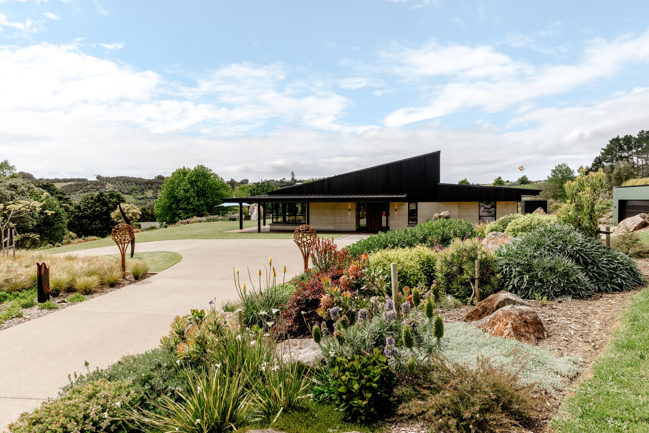 Matakana home with black timber cladding and landscaped grounds